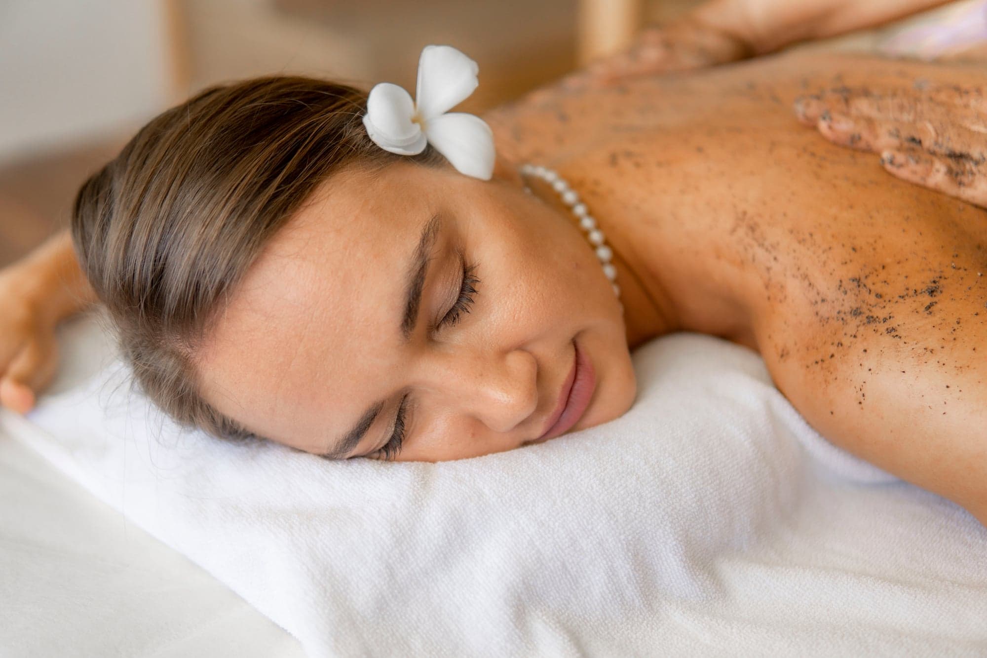 Body scrub on the back, close-up with flower