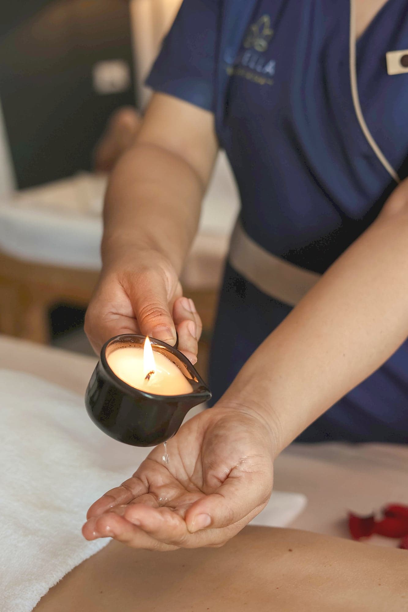 Warm candlelight — soy candle with flame, dripping into a hand